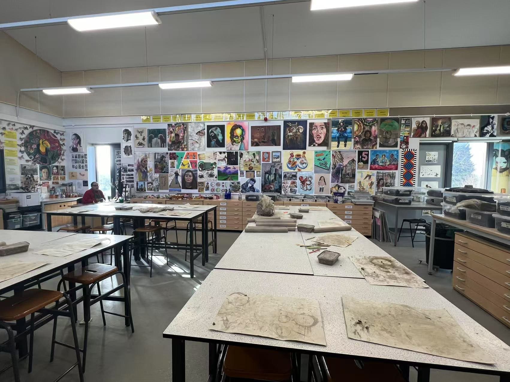 An art studio with pupils' work covering the walls from floor to ceiling